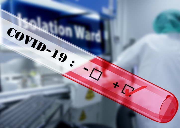 Positive COVID-19 test result in a red test tube with a healthcare worker in an isolation ward background
