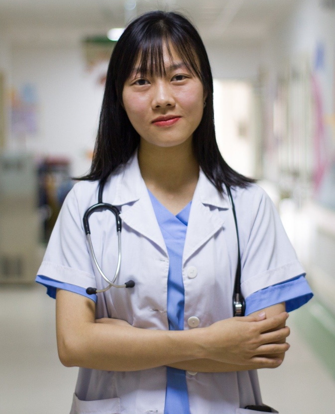 Young female doctor in a white coat with a stethoscope, standing confidently in a clinic hallway at MD Urgent Care.